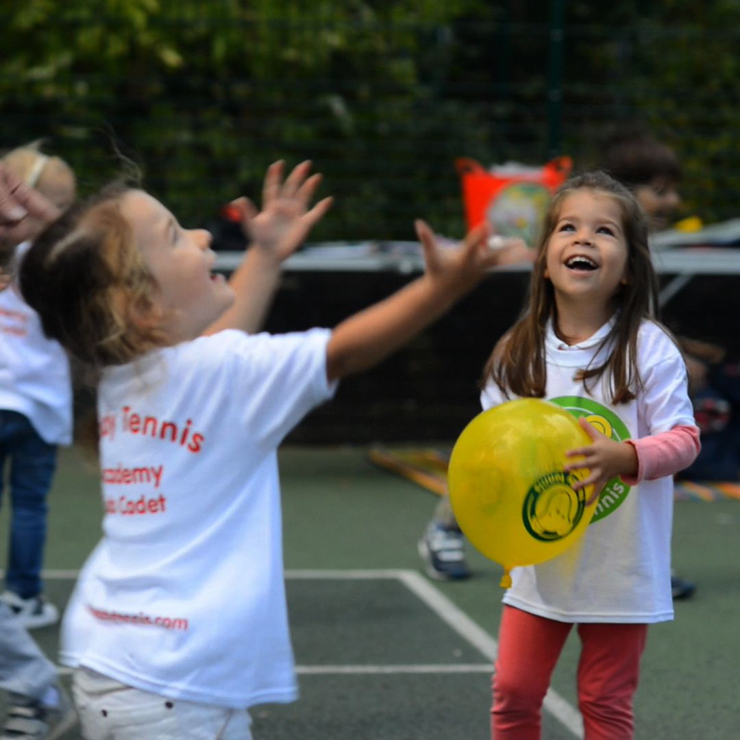 Little girls joyfully playing with bubbles and balloons